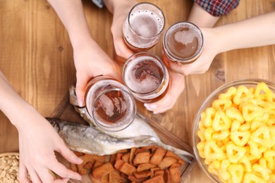 Photo of Friends with beer and snacks at wooden table, top view