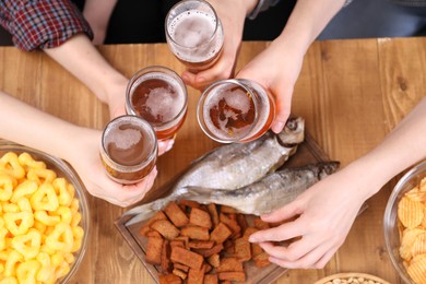Photo of Friends with beer and snacks at wooden table, top view