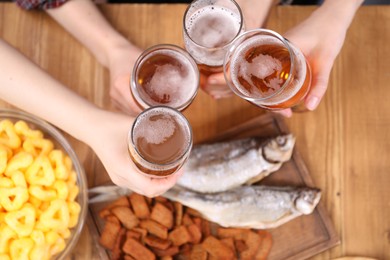 Photo of Friends with beer and snacks at wooden table, top view
