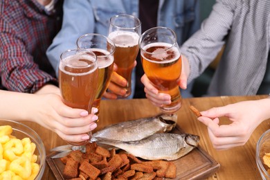 Photo of Friends with beer and snacks at wooden table, closeup