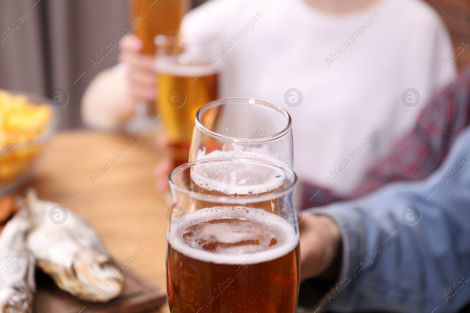 Friends having refreshing beer at home, closeup Photo of Friends having refreshing beer at home, closeup