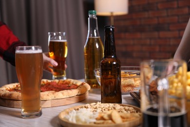 Photo of Friends with beer and snacks at table, closeup
