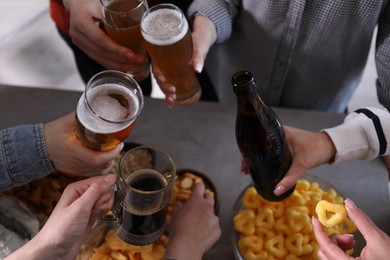 Photo of Friends with beer and snacks at grey table, closeup