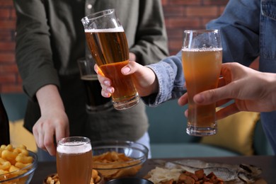 Photo of Friends with beer and snacks at table, closeup