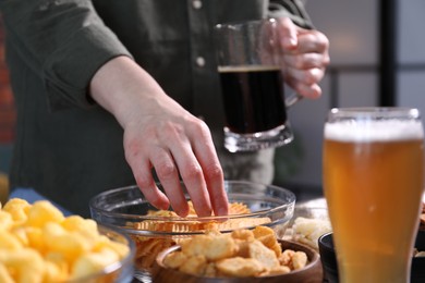 Photo of Woman with beer and chips indoors, closeup
