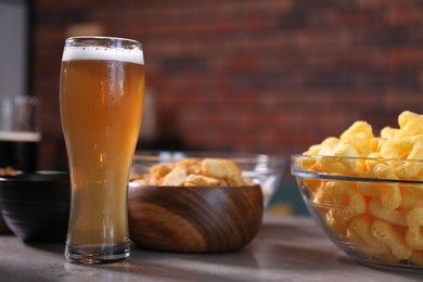 Photo of Beer and snacks on grey table indoors, closeup