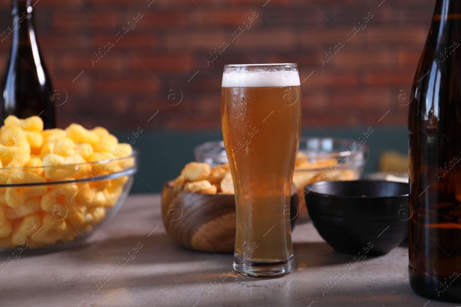 Beer and snacks on grey table indoors, closeup Photo of Beer and snacks on grey table indoors, closeup