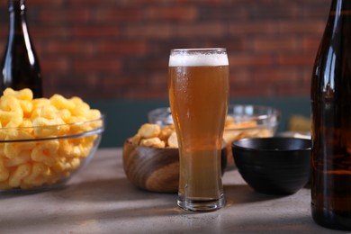 Photo of Beer and snacks on grey table indoors, closeup