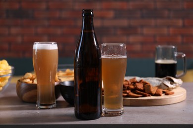 Photo of Beer and snacks on grey table indoors, closeup