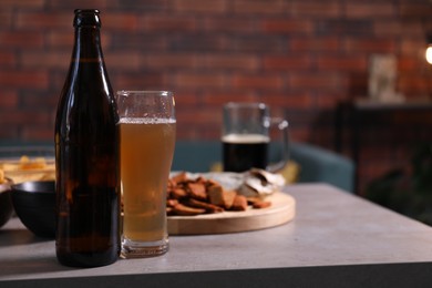 Photo of Beer and snacks on grey table indoors, closeup