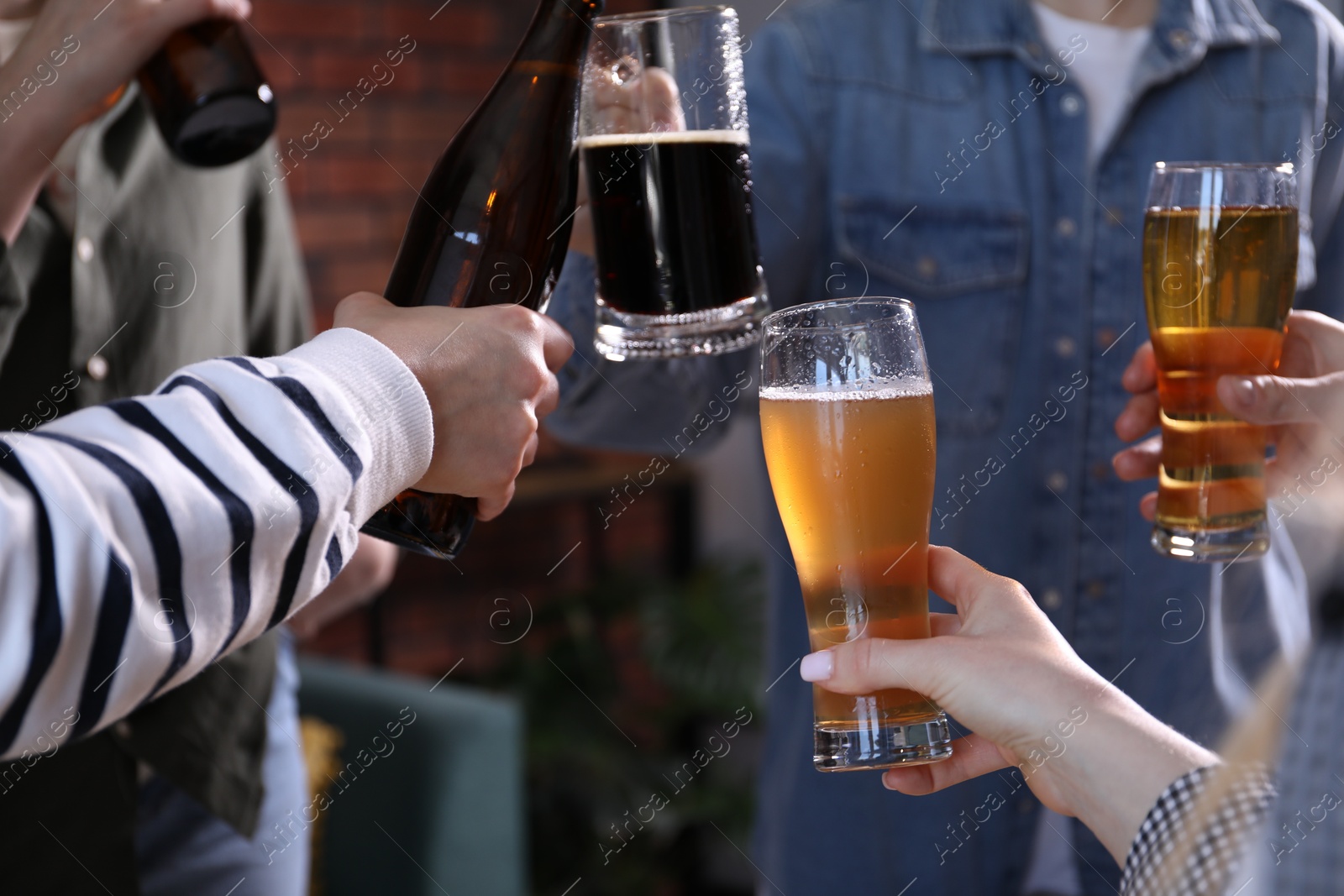 Friends having refreshing beer at home, closeup Photo of Friends having refreshing beer at home, closeup
