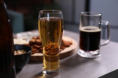 Photo of Beer and snacks on grey table indoors, closeup
