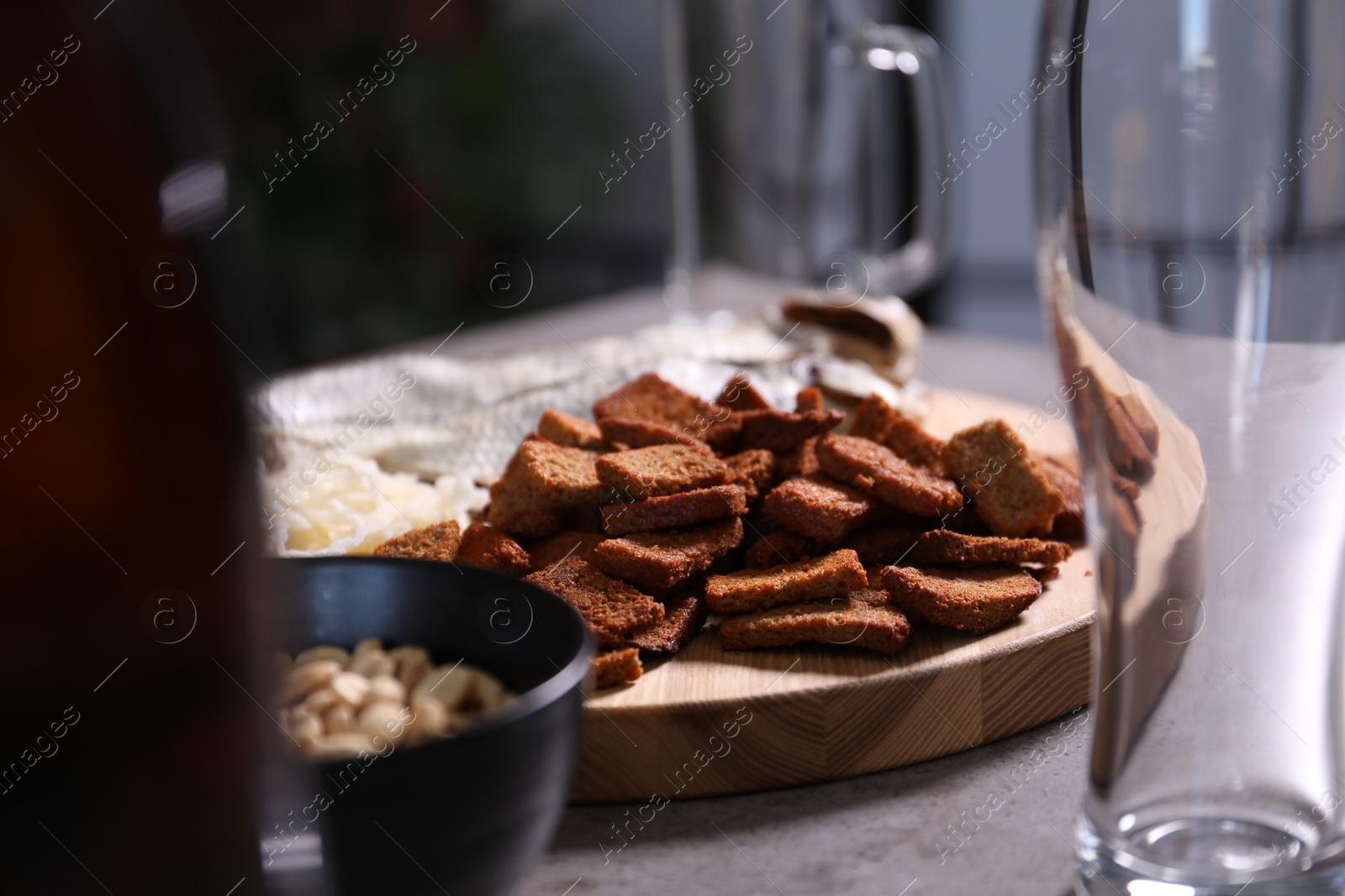 Empty beer glasses and snacks on grey table indoors, closeup Photo of Empty beer glasses and snacks on grey table indoors, closeup