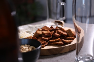 Photo of Empty beer glasses and snacks on grey table indoors, closeup