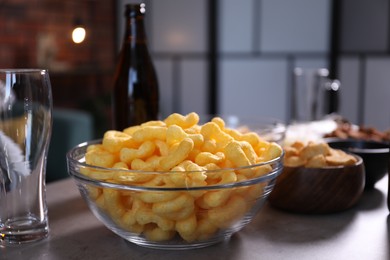 Photo of Beer, glasses and snacks on grey table indoors, closeup