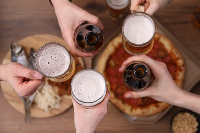 Photo of Friends with beer and snacks at wooden table, top view