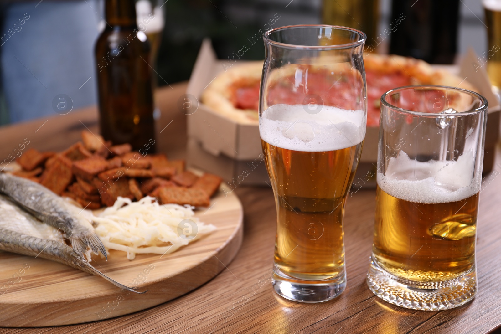 Beer and snacks on wooden table indoors, closeup Photo of Beer and snacks on wooden table indoors, closeup