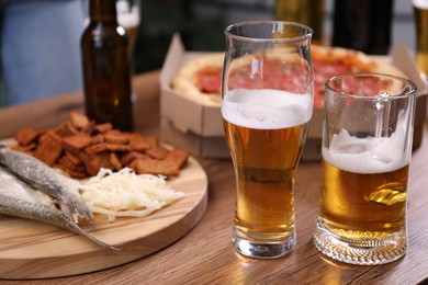 Photo of Beer and snacks on wooden table indoors, closeup