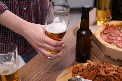 Photo of Woman with beer and snacks at wooden table, closeup