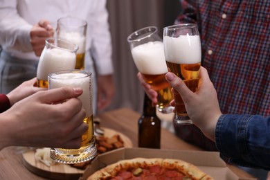 Photo of Friends with beer and snacks at wooden table, closeup
