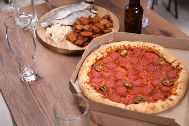Photo of Empty beer glasses and snacks on wooden table indoors, closeup