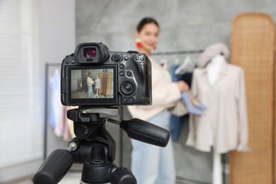 Photo of Professional stylist filming video on camera indoors, selective focus