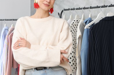 Photo of Portrait of professional stylist near clothing rack indoors