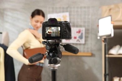 Photo of Professional stylist filming video on camera indoors, selective focus