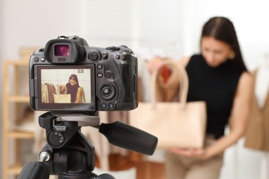 Photo of Professional stylist filming video on camera indoors, selective focus