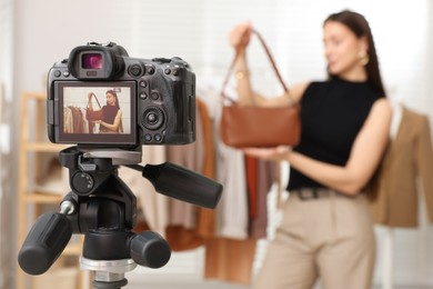 Photo of Professional stylist filming video on camera indoors, selective focus