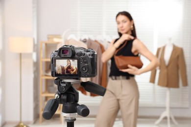 Photo of Professional stylist filming video on camera indoors, selective focus
