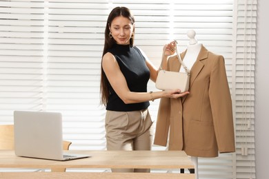 Photo of Professional stylist having online consultation with client via laptop indoors