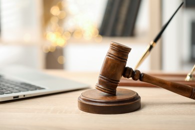 Photo of Judge's gavel on wooden table in office, closeup. Bokeh effect