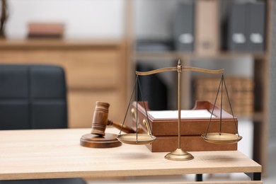 Photo of Judge's gavel, scales and document tray on wooden table in office, space for text
