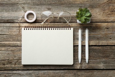 Photo of Flat lay composition with open blank notebook on wooden table