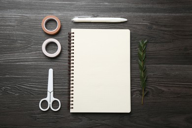 Photo of Flat lay composition with open blank notebook on black wooden table