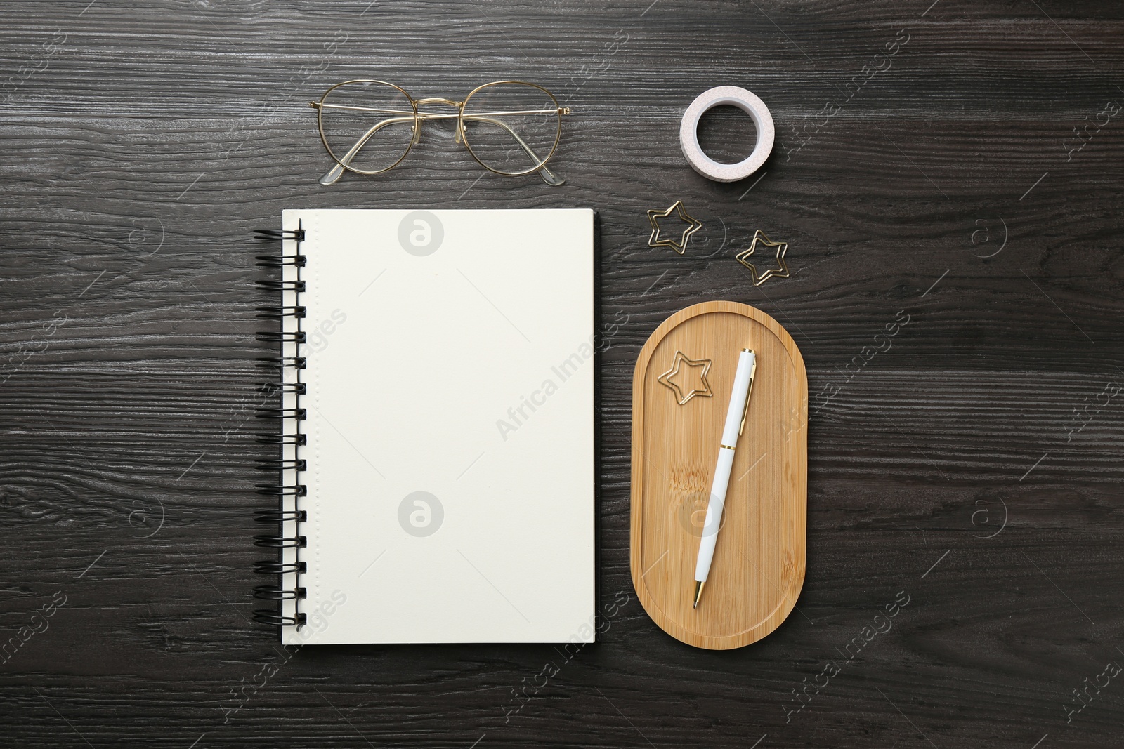 Photo of Flat lay composition with open blank notebook on black wooden table