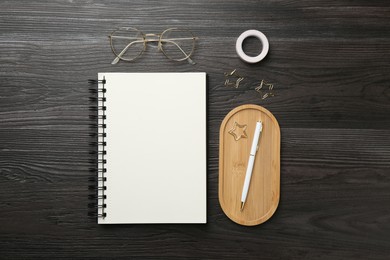 Photo of Flat lay composition with open blank notebook on black wooden table