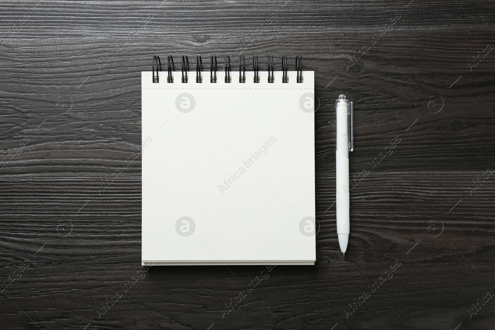 Open blank notebook and pen on black wooden table, top view Photo of Open blank notebook and pen on black wooden table, top view