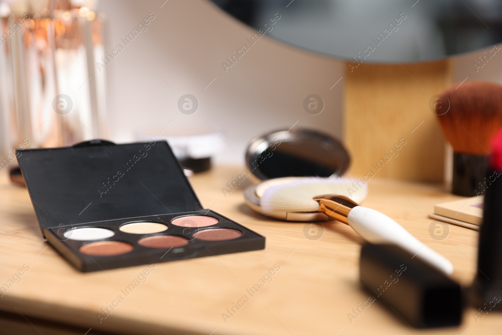Different makeup products on wooden vanity indoors, closeup Photo of Different makeup products on wooden vanity indoors, closeup