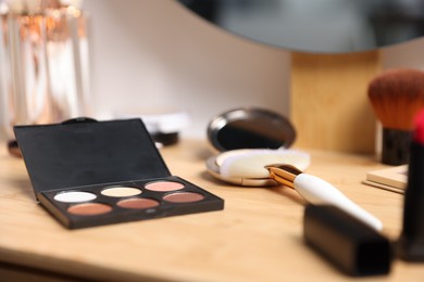 Photo of Different makeup products on wooden vanity indoors, closeup