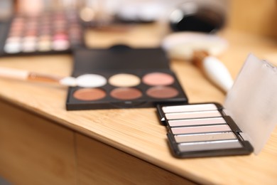 Photo of Different makeup products on wooden vanity indoors, closeup