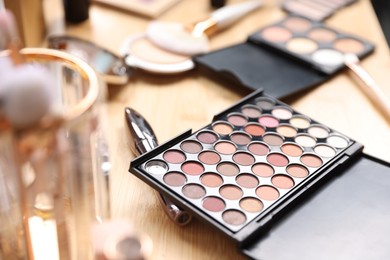 Photo of Different makeup products on wooden vanity, closeup