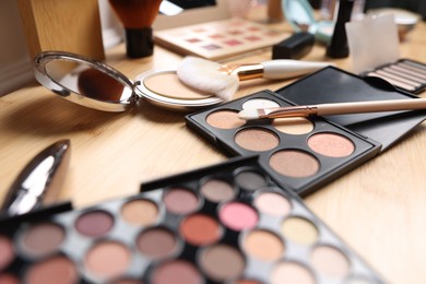 Photo of Different makeup products on wooden vanity, closeup