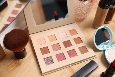 Photo of Different makeup products on wooden vanity, closeup