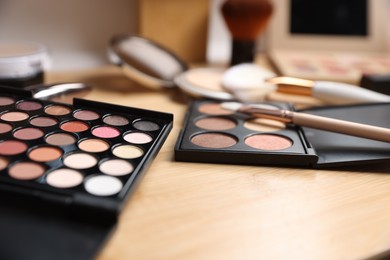 Photo of Different makeup products on wooden vanity indoors, closeup
