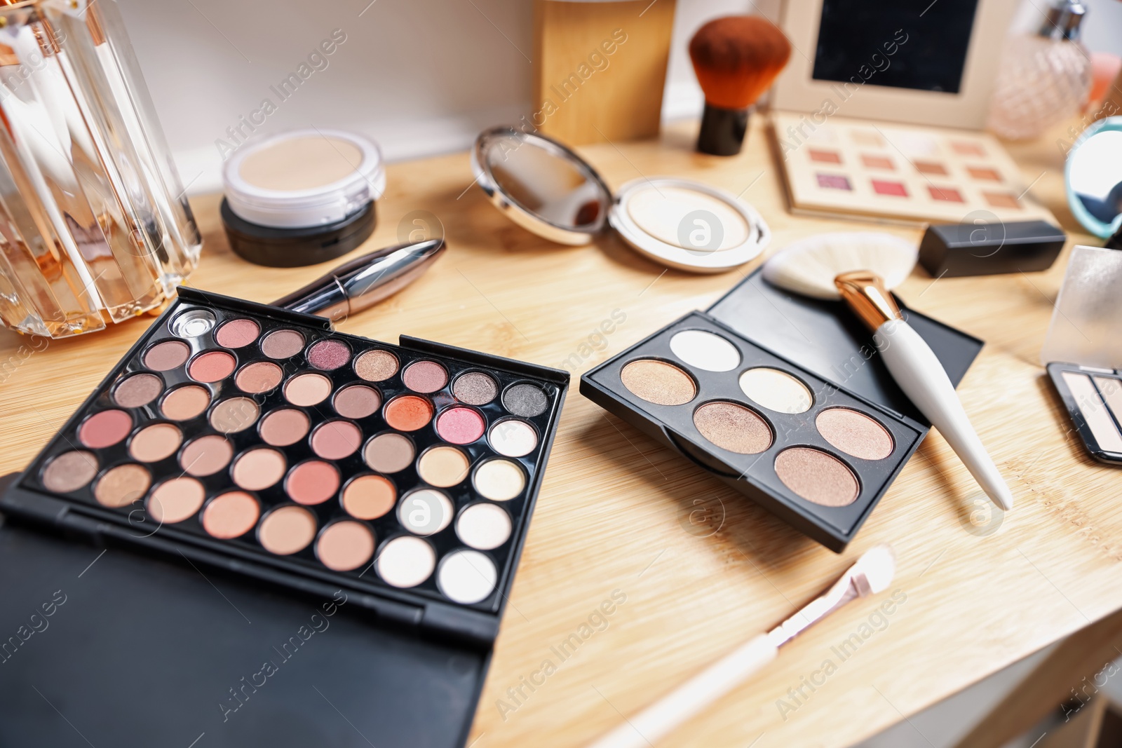 Different makeup products on wooden vanity indoors, closeup Photo of Different makeup products on wooden vanity indoors, closeup