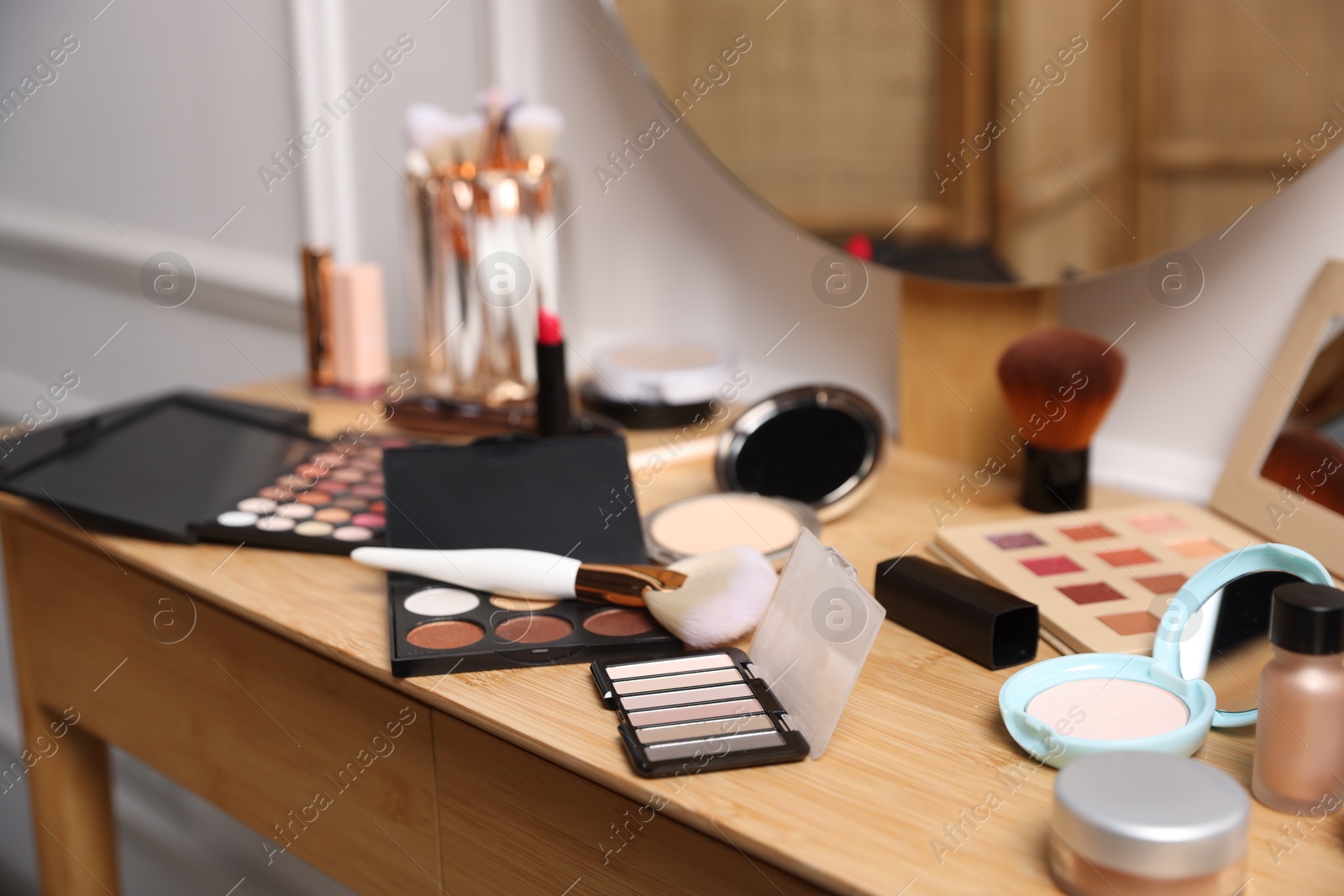 Different makeup products on wooden vanity indoors, closeup Photo of Different makeup products on wooden vanity indoors, closeup