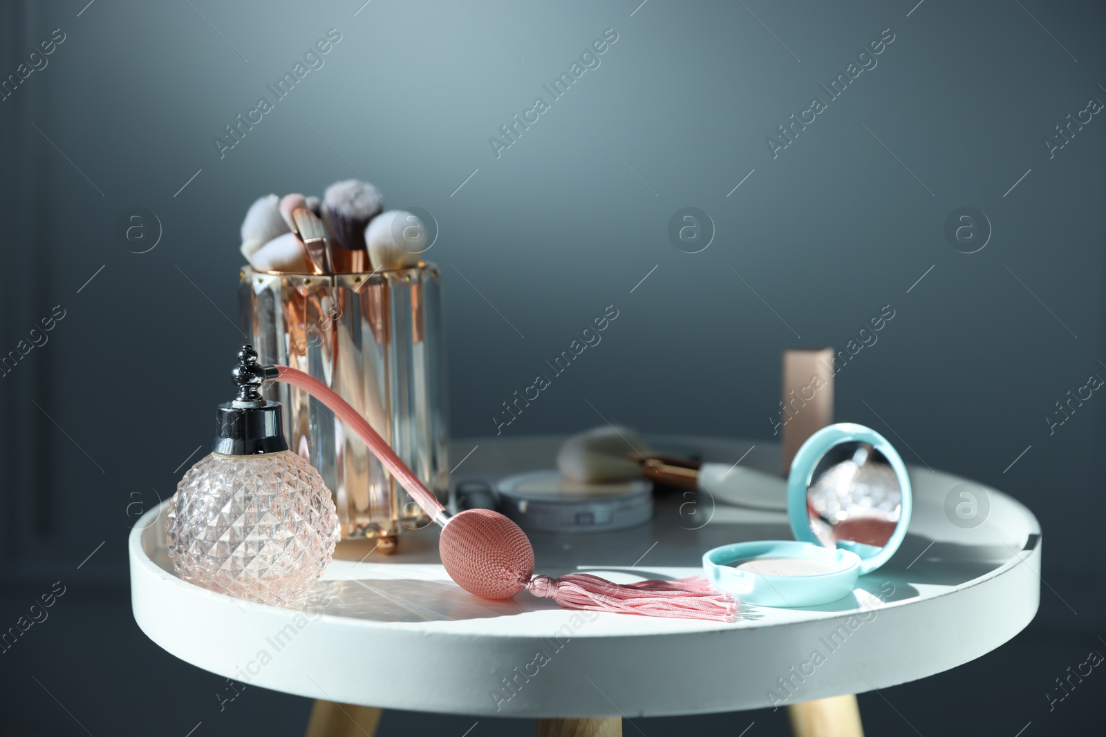 Different makeup products on white table against grey background, closeup Photo of Different makeup products on white table against grey background, closeup