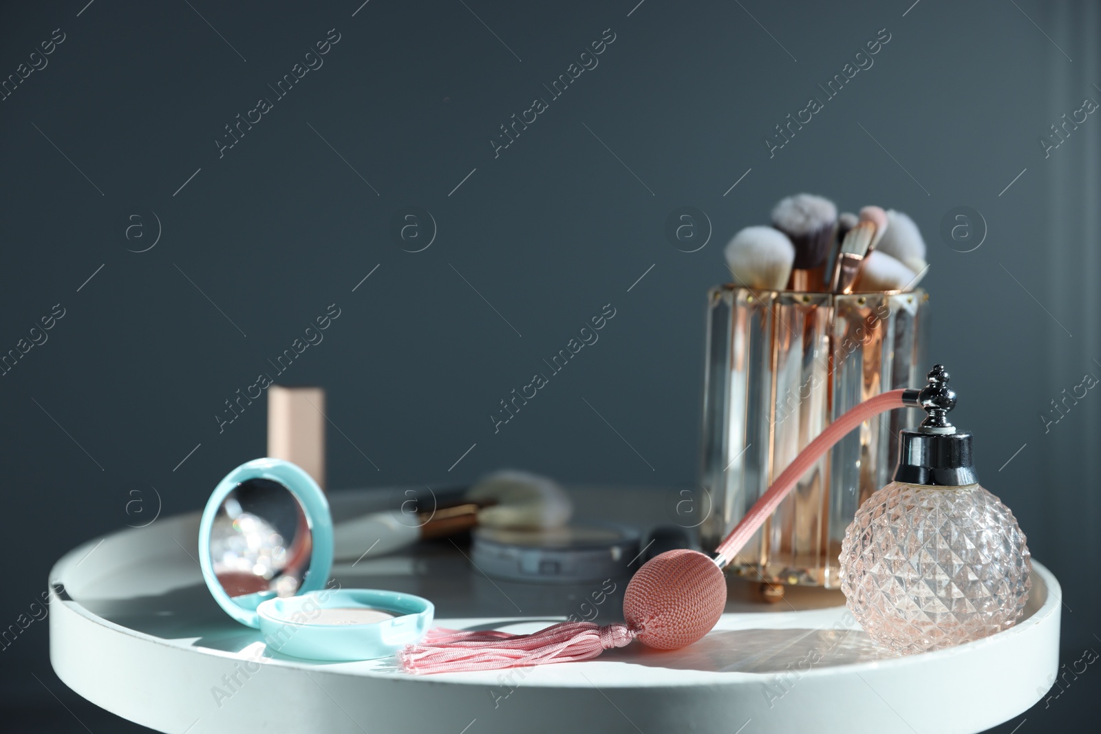 Different makeup products on white table against grey background, closeup Photo of Different makeup products on white table against grey background, closeup